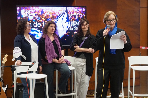 Bandera lila sobre multitud de gent, símbol del 8M