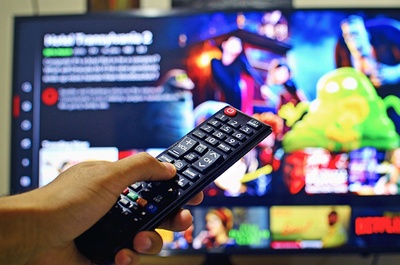 Un comandament davant d'una pantalla de TV