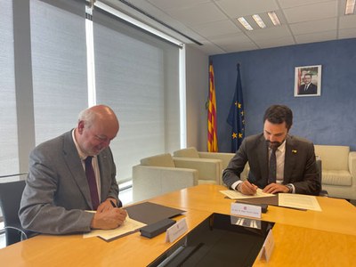 El rector Daniel Crespo i el conseller d’Empresa i Treball, Roger Torrent, signant el contracte