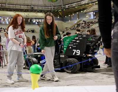 Dues noies participen en una de les activitats, davant del vehicle e-Tech Racing de l'EEBE