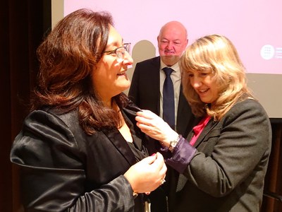 La professora Núria Salán, en el moment de rebre la insígnia d’or, de mans de la presidenta del Consell Social, Montserrat Guàrdia, i del rector, Daniel Crespo