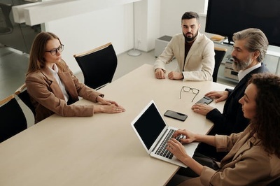 Grup de persones treballant juntes en una sala.