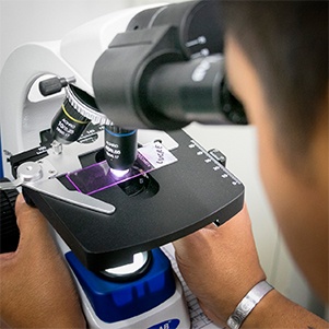 Close-up of researcher looking through microscope