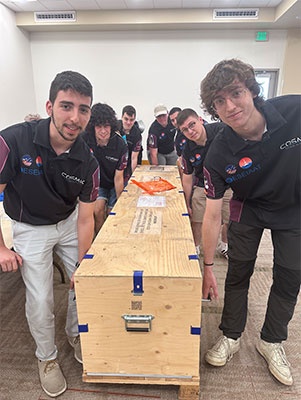 The team transporting the rocket in its safety box.