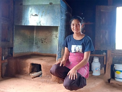 Una mujer de una población de la zona rural de Bhimpedi, en Nepal, a unos 50 kilómetros de la capital, con un horno instalado