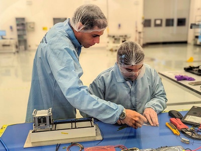 Los doctorandos Amadeu Gonga y Siles y Guillem Gràcia y Solà, en la Sala Blanca del NSSTC, en Al-Ain (Emiratos Árabes Unidos), durante la integración de la RITA/3Cat-6 dentro del satélite AlAinSat-1.