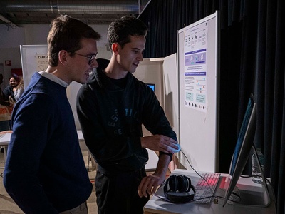 Un estudiante mostrando el proyecto presentado a un compañero