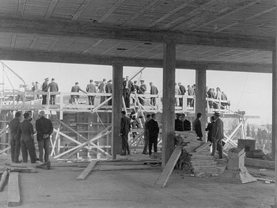 Grupo de visitantes institucionales y personal de la construcción mirando las obras del edificio H, sede de la ETSEIB en la Avenida Diagonal de Barcelona, en 1964