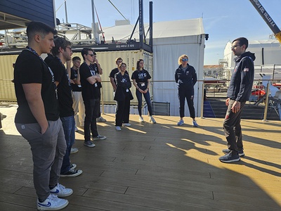 Estudiantes conversando con el ingeniero David Oliver (a la derecha) sobre algunas de las tecnologías que utiliza el equipo