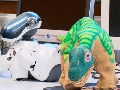 Dos robots mascota, en primer término un dinosaurio