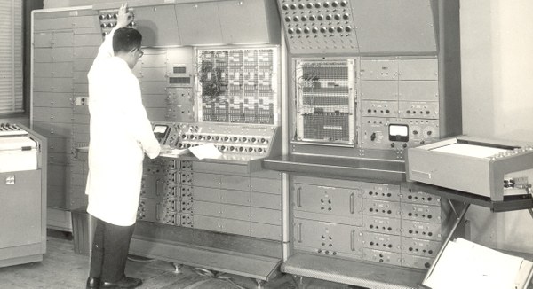 Dues persones interactuant amb el primer ordinador electrònic de l'ETSEIB (Digital IBM 1620)